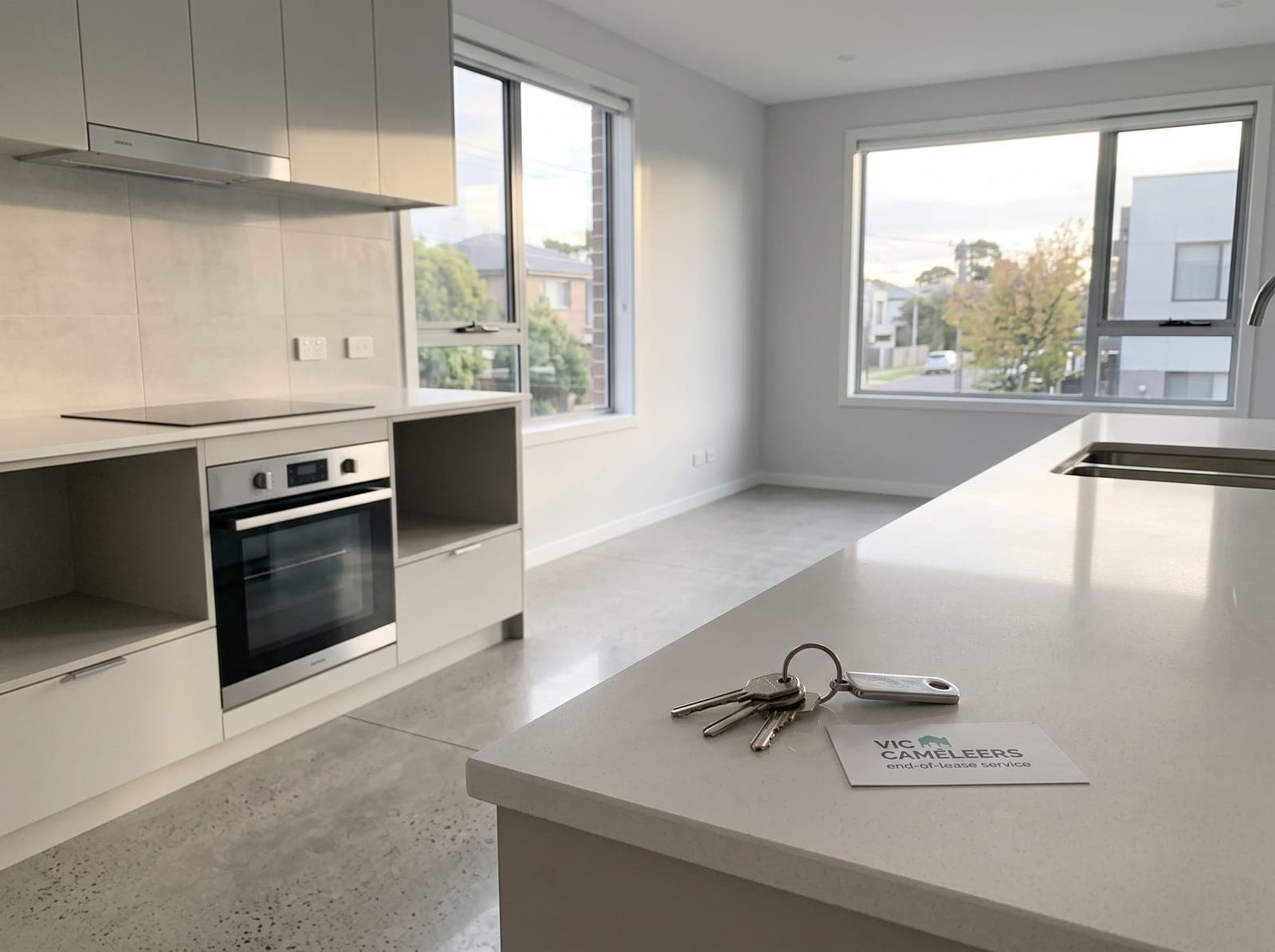 An empty, clean kitchen after a move, with a set of keys left on the benchtop